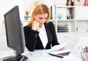 Portrait of upset woman working with papers in office, having stressful business day