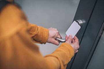 Close up of mans hand opening the door with an access card