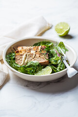 Fried tofu with green salad and nut dressing in white bowl. Asian cuisine, vegan food concept.