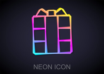 Glowing neon line Gift box icon isolated on black background. Vector