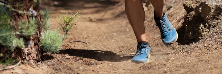 Trail running man on mountain path exercising
