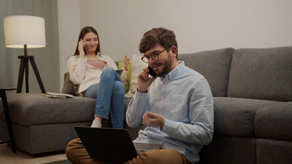 White European man and woman talking on the phone in the room