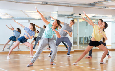 Fototapeta na wymiar Dancing group of five teenagers practicing new dance in studio