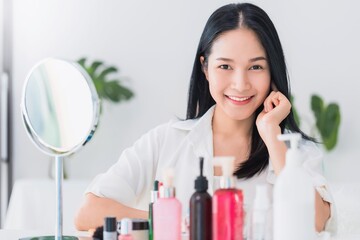 Beautiful asian woman blogger is showing how to make up and use cosmetics. In front of the mirror...