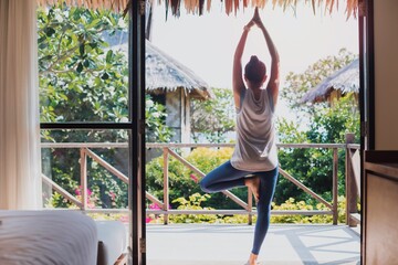 Asian beautiful woman exercise and play yoga at home.Concept of Exercise during the quarantine at home for preventing coronavirus and covid-19 infection.