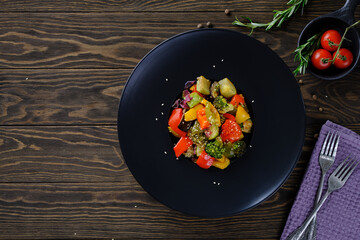 Delicious and useful food. Grilled vegetables on a round black plate on old wooden table