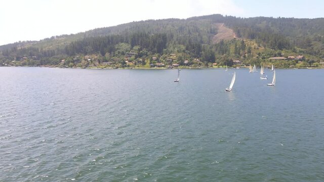 AERIAL - Sailboats during a regatta in Lake Vichuquen, Chile, wide circle pan