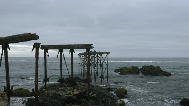 Ruins of the historic, 120-year-old dock in Llico, Vichuquen, Chile, wide shot
