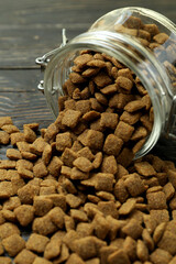 Glass jar with pet feed on wooden background