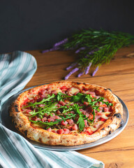 Pizza with seafood and arugula over rustic wooden background. Italian cuisine concept, Italian food.