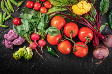 Healthy diet background. Many fresh vegetables, shot from the top on a black background. Summer salad ingredients