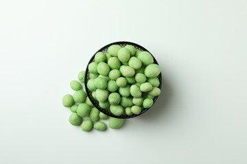 Bowl of wasabi nuts on white background
