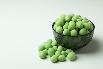 Bowl of wasabi nuts on white background