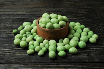 Bowl of wasabi nuts on rustic wooden background
