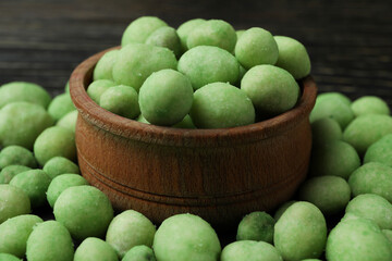 Bowl of wasabi nuts on rustic wooden background