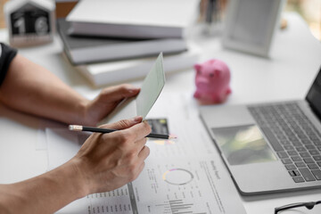 Saving and growth money concept bookkeeper using calculator, laptop computer and holding passbook...