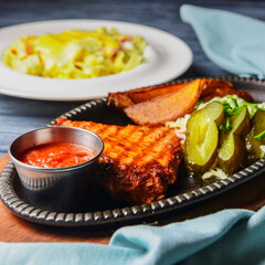 Juicy grilled pork steak with baked potatoes and one plate of Spaghetti pasta with cheese and pepper