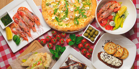 Traditional Italian cuisine concept flat lay. Sea food pizza, cooked shrimps, caramel ribs, ham pita sandwich.