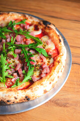 Pizza with seafood and arugula over rustic wooden background. Italian cuisine concept, Italian food.