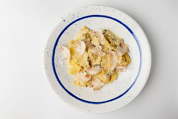 Long spaghetti pasta with mushrooms and cream served in a qhite plate over white background.