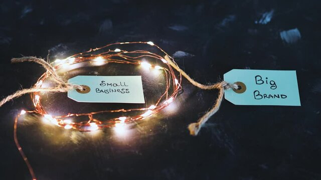 product tags with small business vs big brand texts with fairy lights on the small one, concept of customer behaviour and supporting small businesses