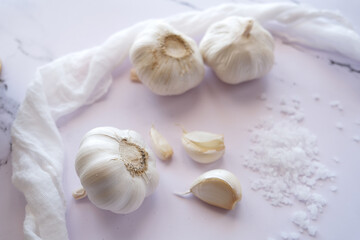 Obraz na płótnie Canvas Whole garlic, garlic cloves and fabric on a white background