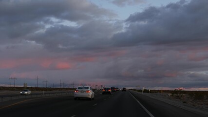 Road trip, driving auto from Death Valley to Las Vegas, Nevada USA. Hitchhiking traveling in America. Highway journey, dramatic atmosphere, sunset mountain and Mojave desert wilderness. View from car.