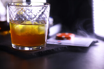 Gambling Card games for money. Texas Hold'em Poker. Cards in hand, playing chips, deck of cards of alcohol in a glass.