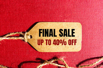 FINAL SALE UP TO 40 percent text on a brown tag on a red paper background