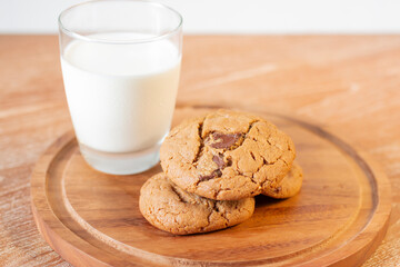 Delicious Chocolate Chip Cookies on wooden plate on wooden table. Fresh baked chocolate chip cookies on rustic wooden table. Homemade Chocolate Chip Cookies on a plate on a wooden table.