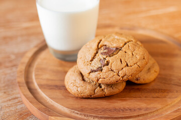 Delicious Chocolate Chip Cookies on wooden plate on wooden table. Fresh baked chocolate chip cookies on rustic wooden table. Homemade Chocolate Chip Cookies on a plate on a wooden table.