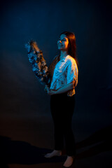 Girl in a shirt with pipidustre illuminated by complementary light