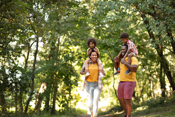  African American family walking trough park. - Powered by Adobe