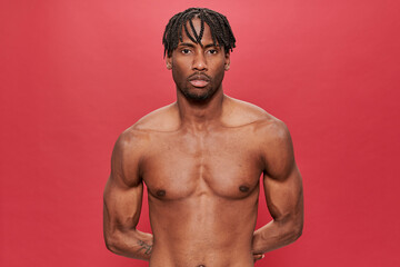 Black man without shirt on red background