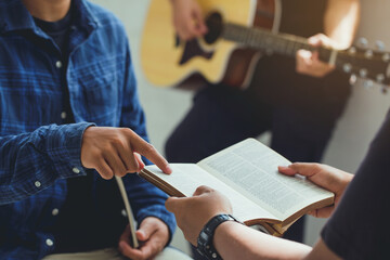 Christian family worship God in home with  playing guitar, and holding holy bible .Group...