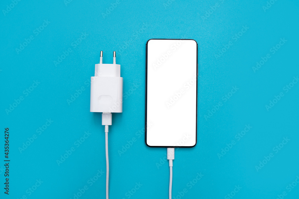 Wall mural smartphone with white phone screen and power supply, phone charger on a blue background. usb cable f