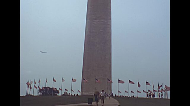 Washington Monument obelisk in the 1980s in Washington DC capital city. Surrounded by American flags, in National Mall park of the United States. Historical archival of America in the year 1981.