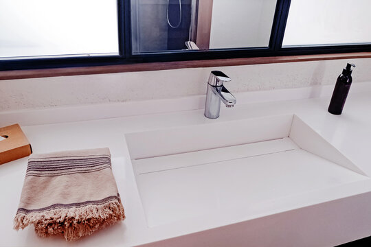 Wash basin in modern bathroom interior, towel and liquid soap.