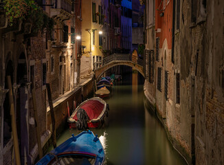 Fototapeta na wymiar Narrow canal with bridge in Venice, Italy. Architecture and landmark of Venice. Night cozy cityscape of Venice.