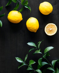 Fresh yellow lemons on black background