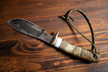 Hunting knife handmade on a wooden background