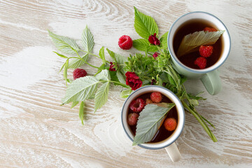 flat lay of raspberry tea mugs on light wooden table