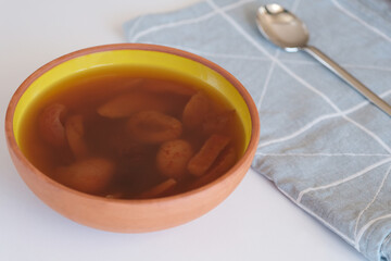 Compote in ceramic bowl on wooden stand.Delicious healthy compote made from dried fruits.
Apricot in spoon