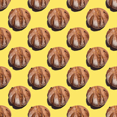 Fresh homemade rustic rye round bread seamless pattern isolated on yellow background, top view, square frame.