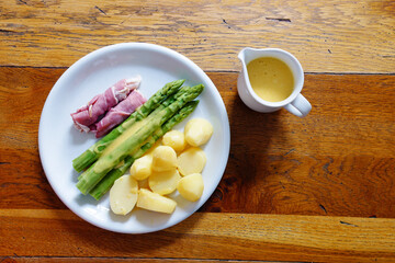 Grüner Spargel mit Sauce Hollandaise über dem Gericht