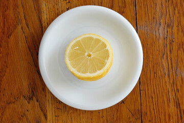 Halbe Zitrone auf weißem Teller