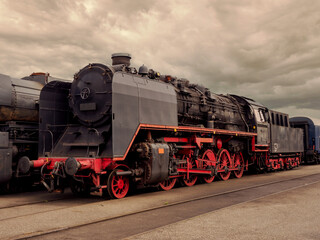 Historical locomotive with dramatic cloudy sky in abandoned industrial area
