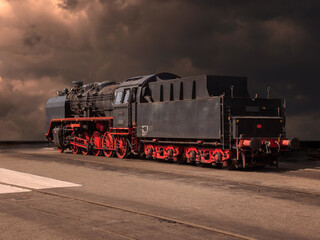 Historical locomotive with dramatic cloudy sky in abandoned industrial area