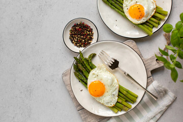 Homemade asparagus with stir-fried eggs, top view, light grey background. Copy space.