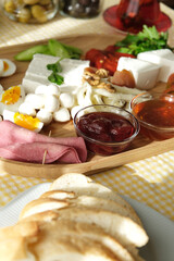 Delicious traditional turkish breakfast on yellow checkered tablecloth.
Tea, olives, eggs, cheeses, cucumbers, tomatoes